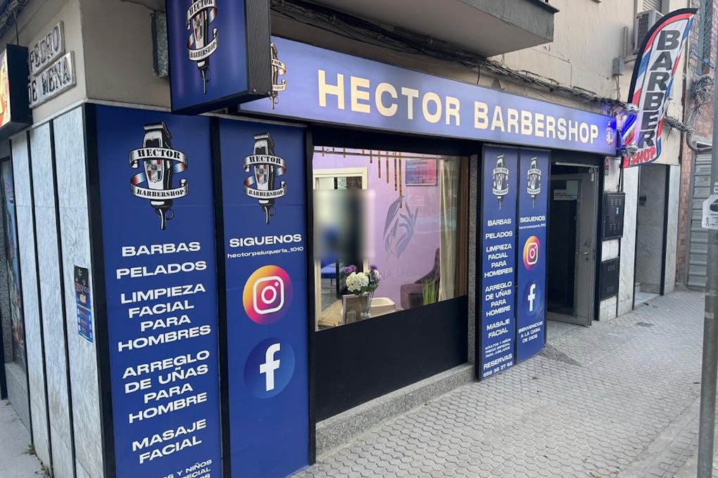 Fachada azul de Hector Barbershop con su logo y la lista de servicios: barbas, pelados, limpieza facial, arreglo de uñas y masaje facial